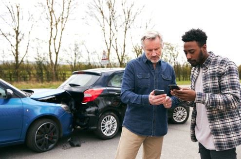 two men exchanging information after car accident