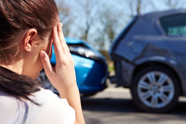 young woman looking at cars after a car accident